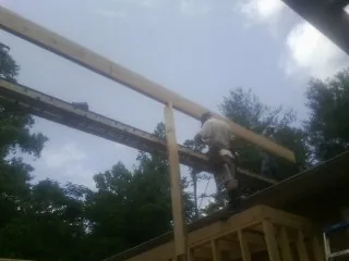 Carpenter setting a ridge beam over a new addition frame — Ice Dam Removal by Roofing Brothers in Washburn
