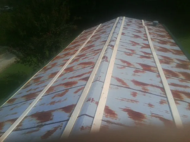 Rusted metal roof panels with new wood purlins before replacement — Storm Damage Roof Repair in Washburn by Roofing Brothers